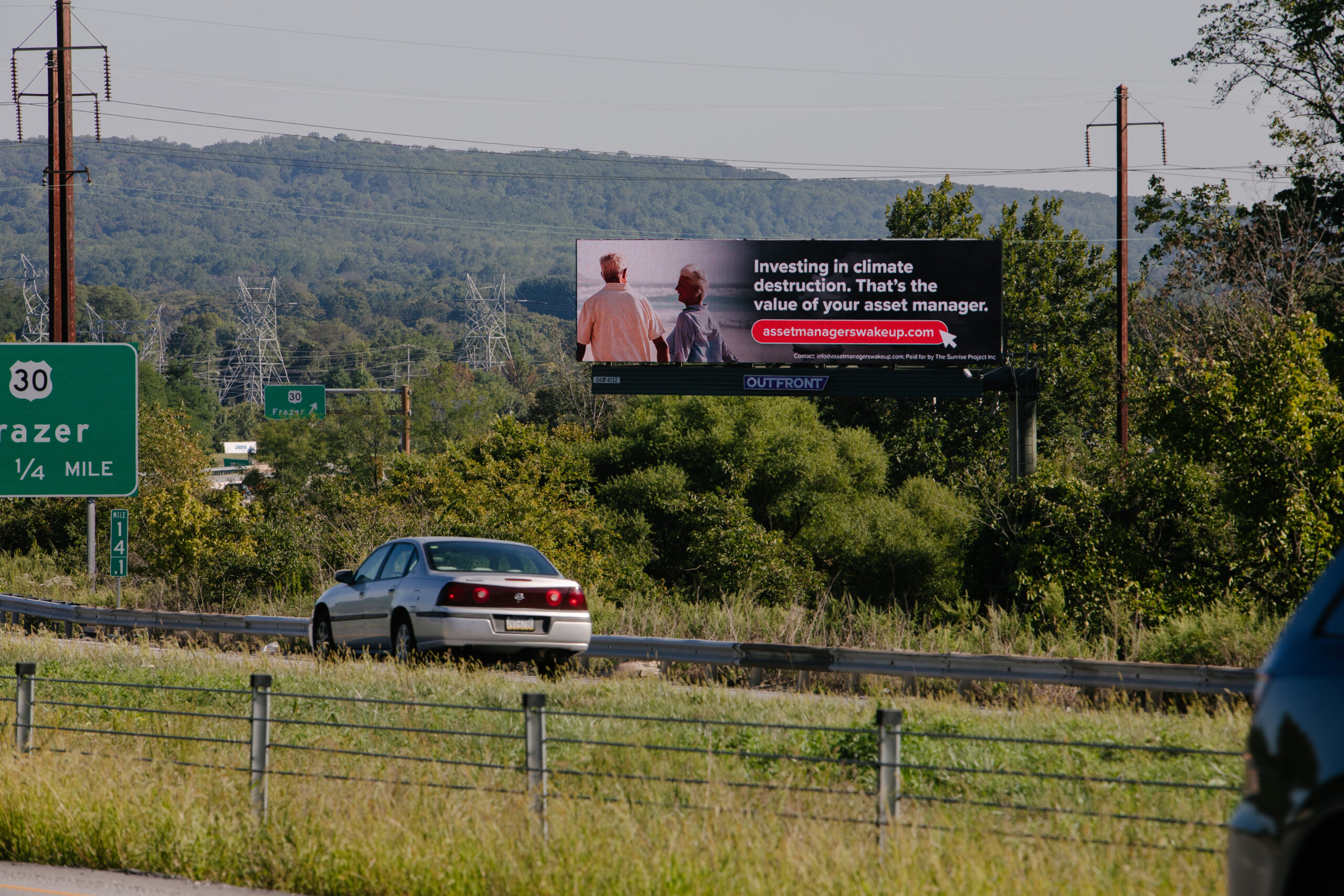 a billboard near Malvern PA is pictured. It says "Investing in climate destruction. That's the value of your asset manager" and is designed to mimic Vanguard ad campaigns.
